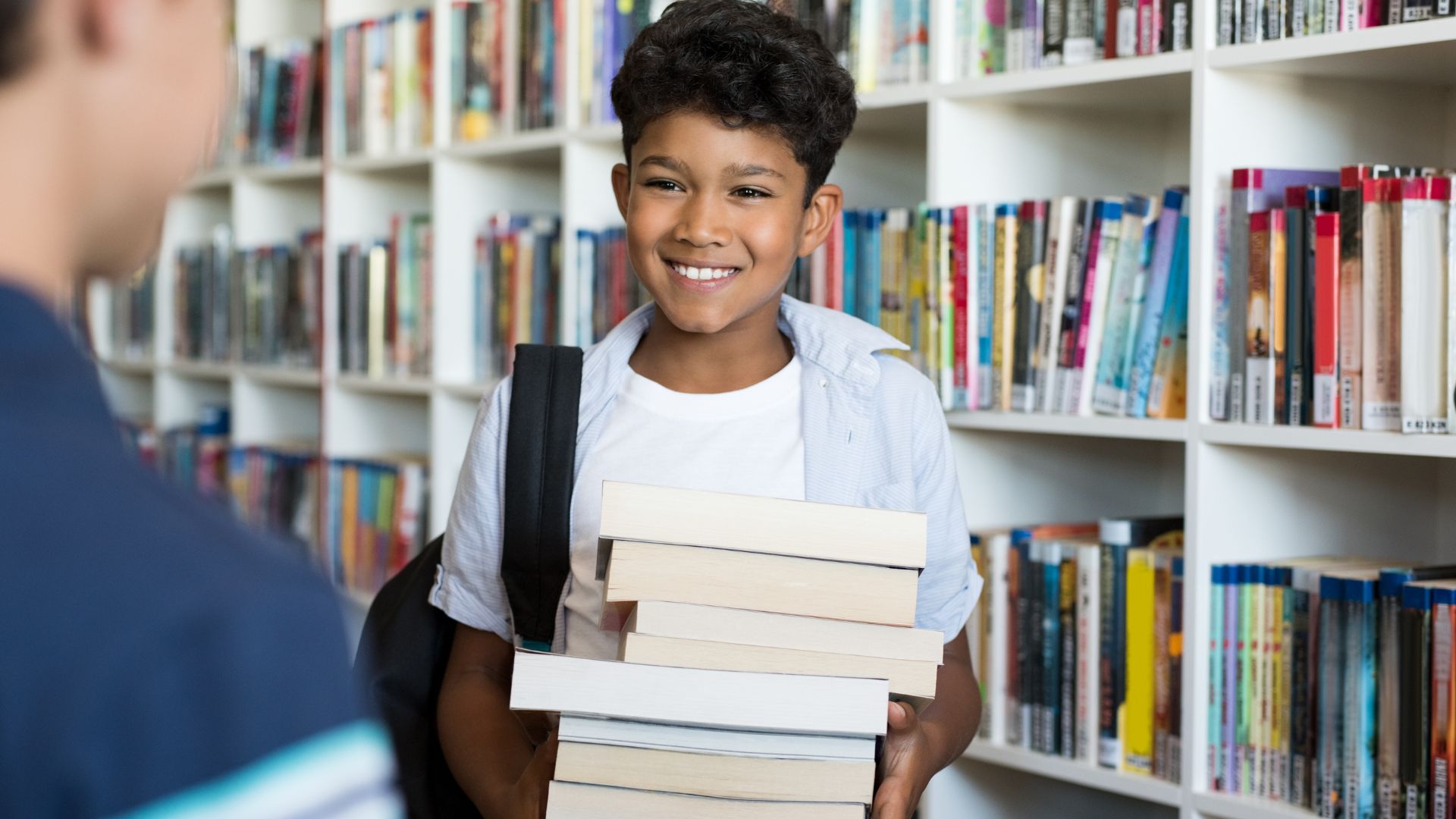 Little Boy Borrowing A Stack Of Books