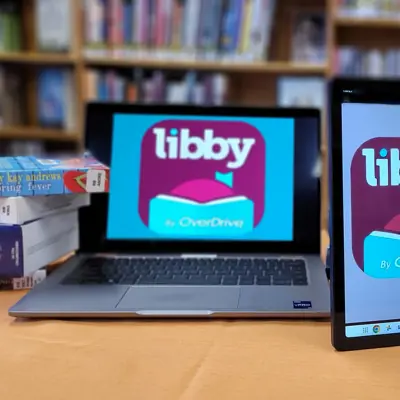 laptop and table on table with books and recorded books