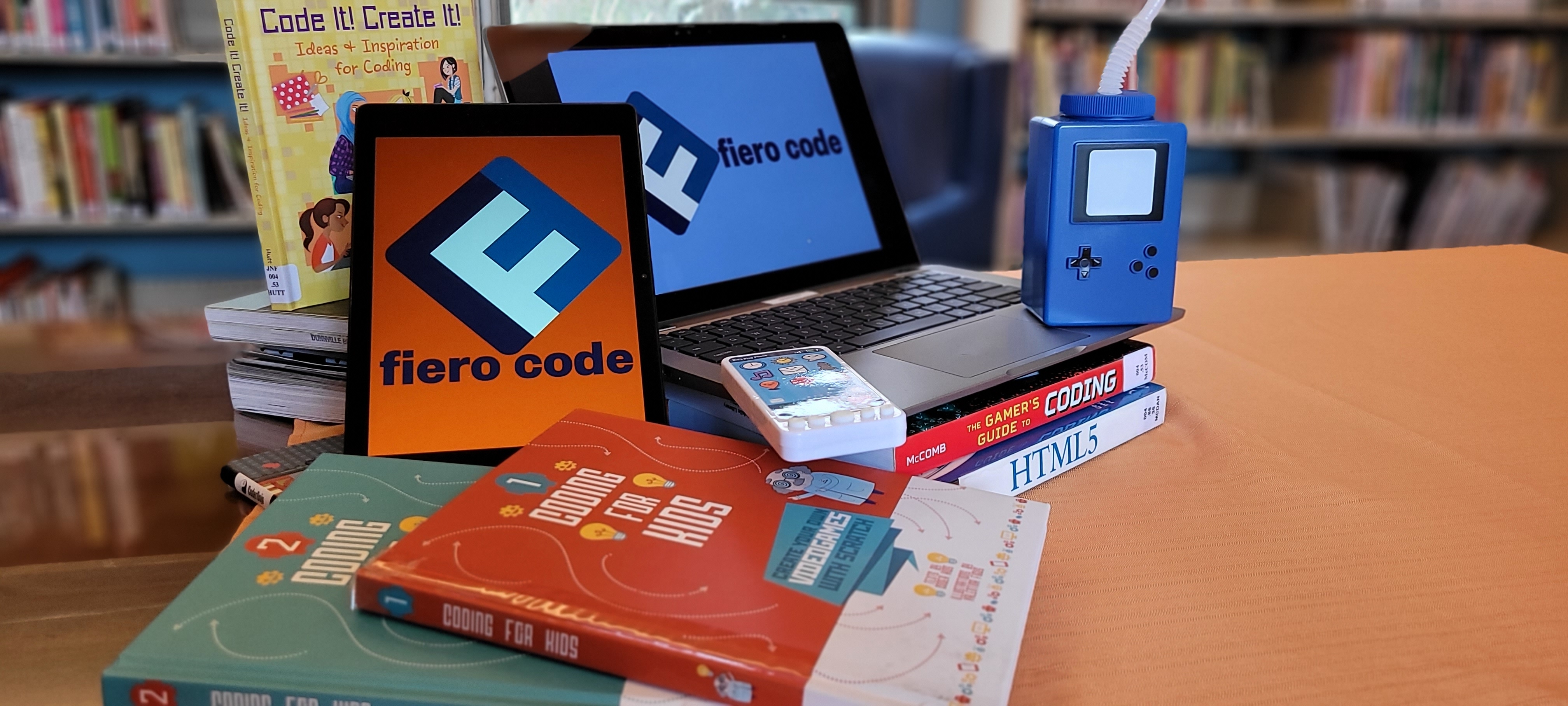 laptop and tablet with coding books