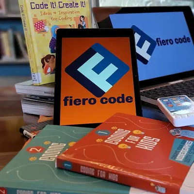 laptop and tablet with coding books
