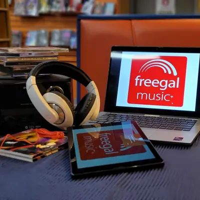 laptop and tablet with cds and headphones on table