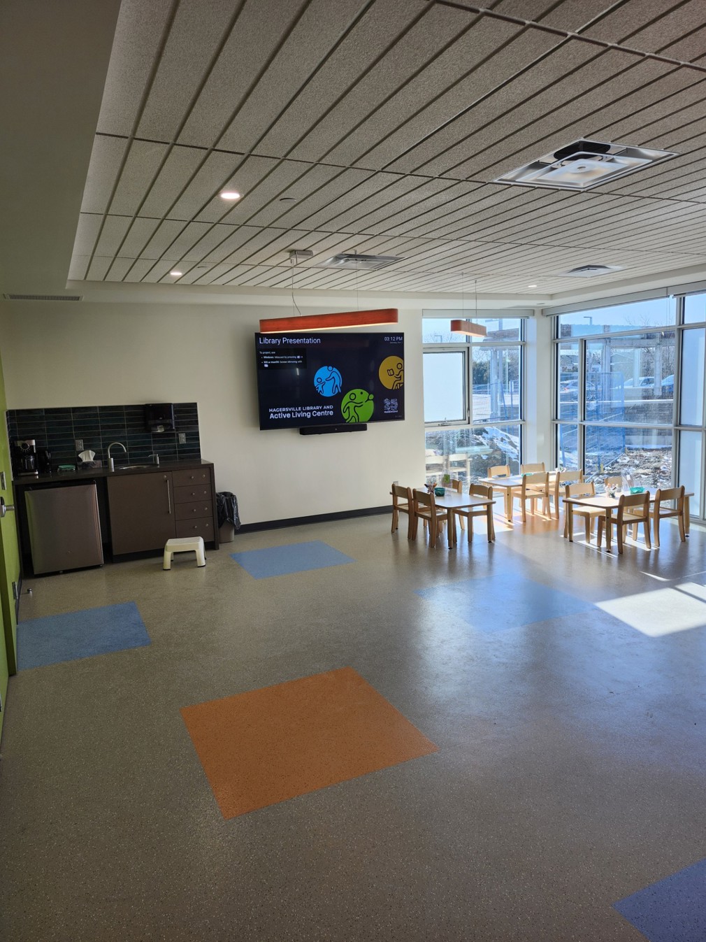 Program room kitchenette and Smart TV with children's tables and chairs