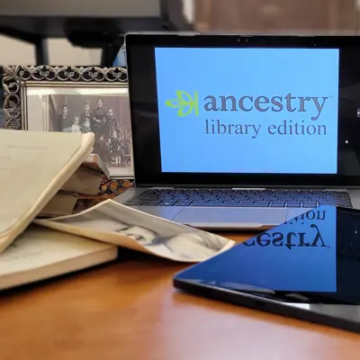 laptop and tablet with local history books and old photo