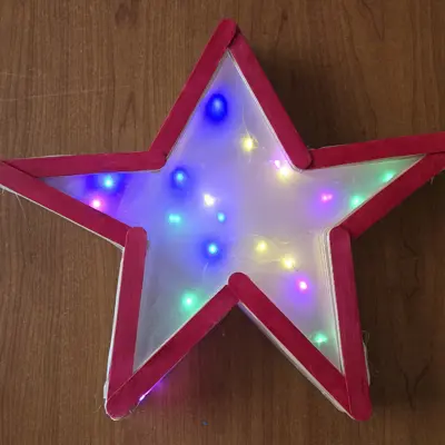 Star made of popsicle sticks with lights